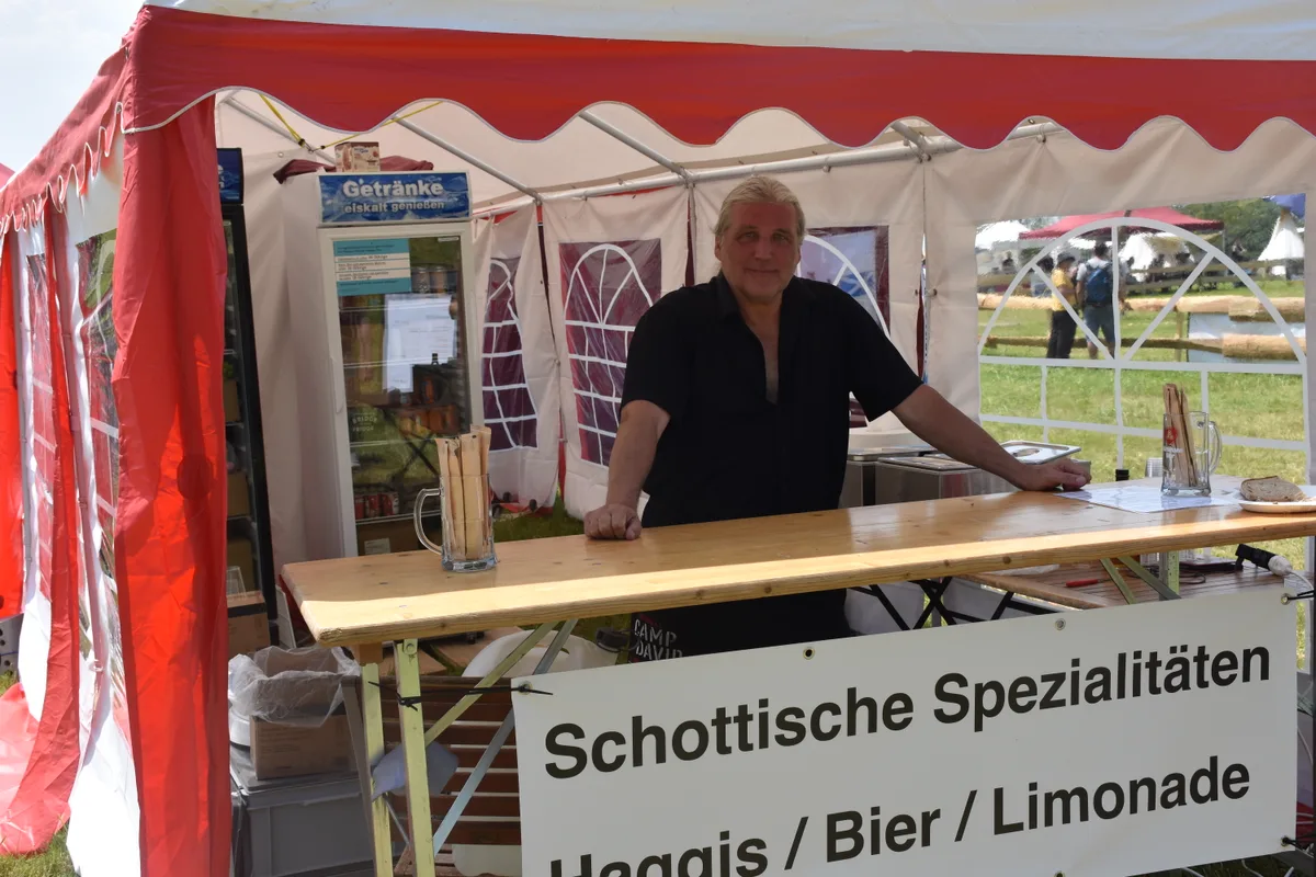 Ein Mann steht bei seinem Stand.